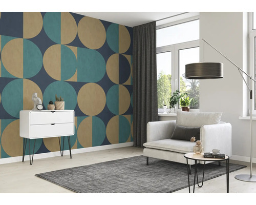 Woonkamer met patroonbehang, fauteuil, tapijt en ladekast