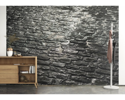 Wanddecoratie met steenmotief in een woonkamer met dressoir en kapstok.