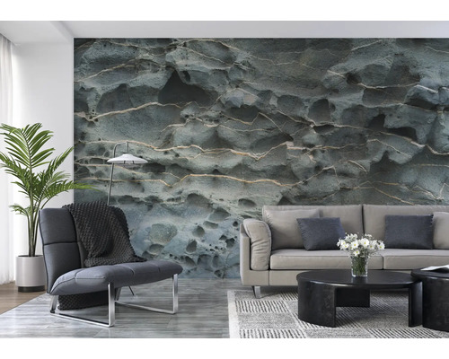 Woonkamer met een bank, een fauteuil en fotobehang met steenmotief