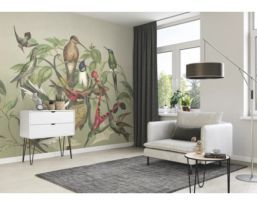 Lichte woonkamer met vogelbehang, fauteuil, ladekast en vloerkleed