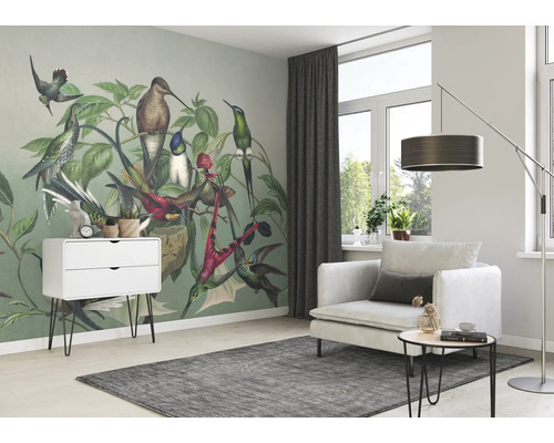 Woonkamer met vogelt behang, fauteuil, vloerkleed en bijzettafel