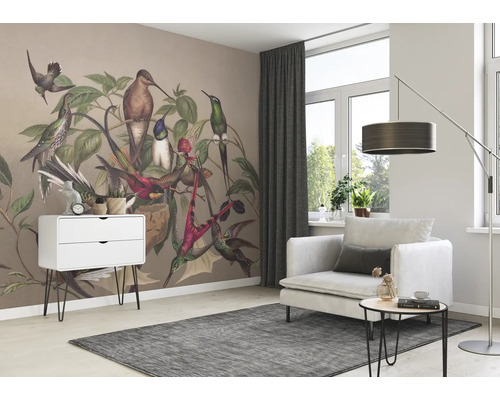 Woonkamer met behang met vogelmotief, fauteuil, tapijt en ladekast