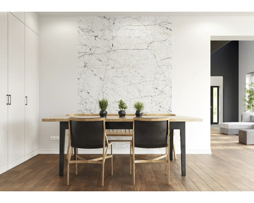 Eetkamer met houten tafel, stoelen en wandbekleding met marmerlook.