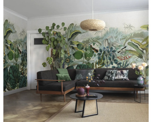 Woonkamer met jungle behang, bank, tafel en lamp