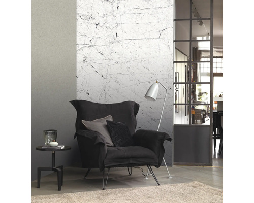 Woonkamer met fauteuil, staande lamp, bijzettafel en marmeren behang