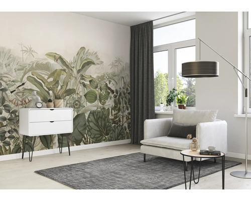 Woonkamer met junglebehang, fauteuil, staande lamp en dressoir