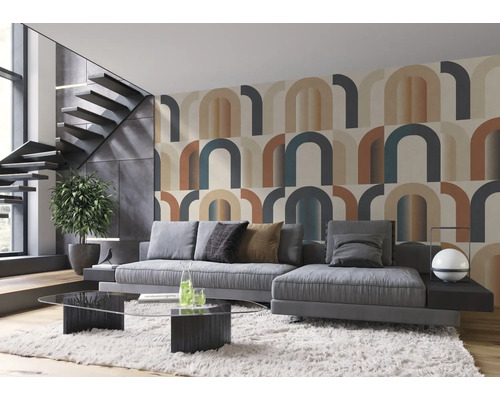 Woonkamer met behang met geometrisch patroon, grijze bank en trap