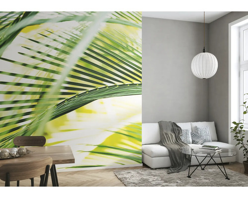 Woonkamer met fotobehang met palmmotief, bank en eettafel