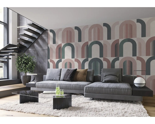 Woonkamer met grijze bank, glazen salontafel en behang met grafisch patroon