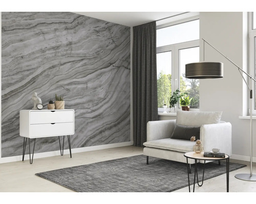 Woonkamer met marmeren behang, fauteuil, ladekast en vloerkleed voor een lichte, moderne sfeer