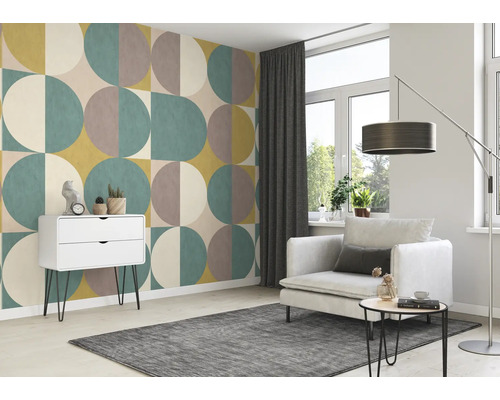 Woonkamer met geometrisch behang, fauteuil, vloerkleed en ladekast