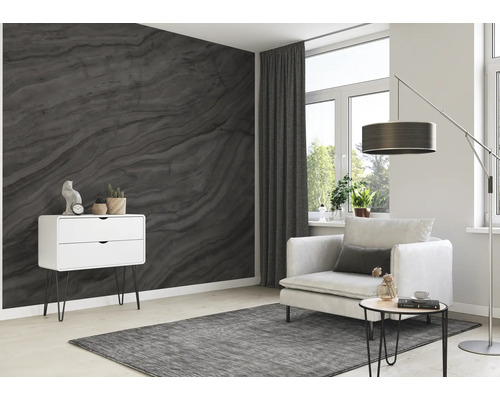 Woonkamer met grijs behang in marmerlook, fauteuil, staande lamp en ladekast