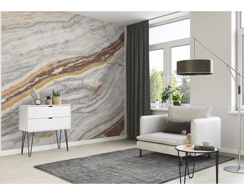 Woonkamer met patroonbehang, fauteuil, vloerkleed en ladekast