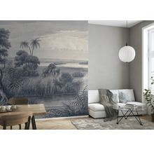 Woonkamer met behang met olifantenmotief, bank, tafel en lamp