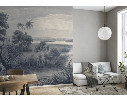 Woonkamer met behang met olifantenmotief, bank, tafel en lamp