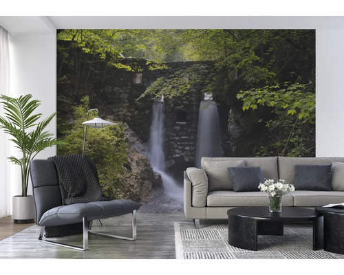 Woonkamer met fotobehang van een waterval in een groen landschap.