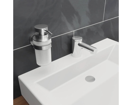 Wastafel met kraan en zeepdispenser in de badkamer