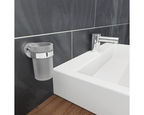 Aan de muur gemonteerde tandenborstelbekerhouder naast een wastafel