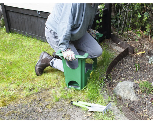 Persoon knielt op een tuinkruk tijdens het tuinieren.
