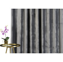 Decoratief gordijn naast een tafel met een orchidee.