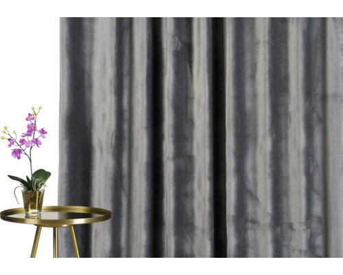 Decoratief gordijn naast een tafel met een orchidee.