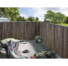 Balkon met privacyscherm van natuurlijke materialen, ligstoel en decoratie