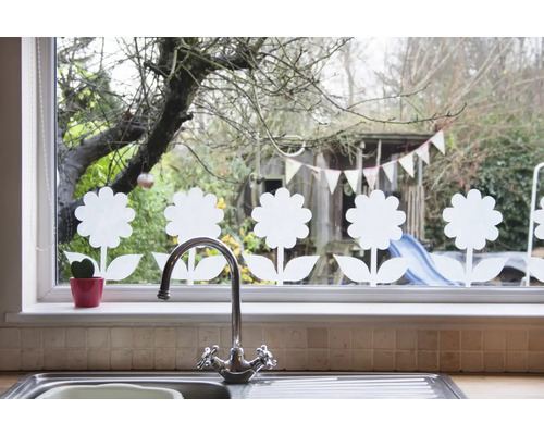 Raamdecoratie met bloemmotieven, gootsteen en kraan op de voorgrond