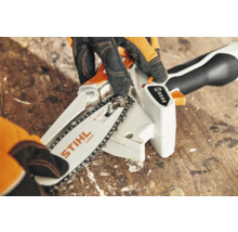 STIHL accukettingzaag in detail met handen die de ketting spannen