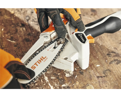 STIHL accukettingzaag in detail met handen die de ketting spannen