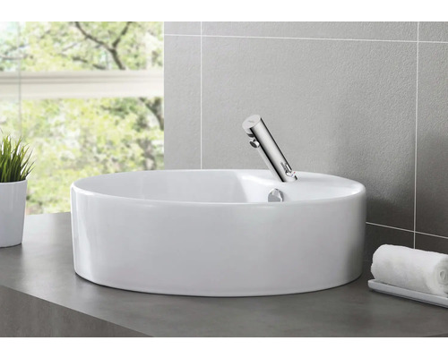 Keramische waskom met kraan in een badkamer.