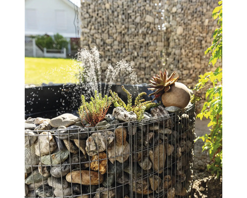 Gabionenfontein met stenen, planten en waterspel in de tuin