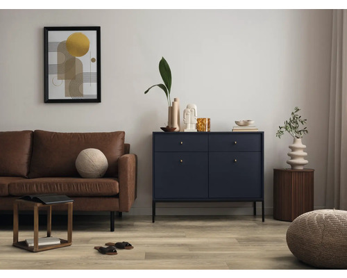 Woonkamer met bruine bank, ladekast en decoratieve objecten voor een stijlvolle sfeer