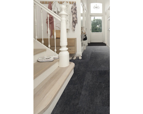 Hal met trap en donkergrijze vloerbedekking.