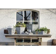Decoratieve plantenbakken van aardewerk op een houten tafel voor een raam