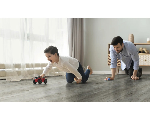 Vader en zoon spelen met speelgoedauto''s op een vloer