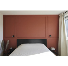 Slaapkamer met wandpanelen, bed en nachtkastjes.