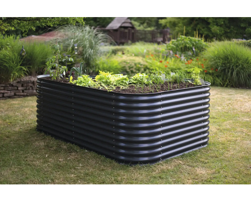 Metalen plantenbak met planten in de tuin.