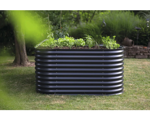 Metalen plantenbak in de tuin met aangeplante groenten