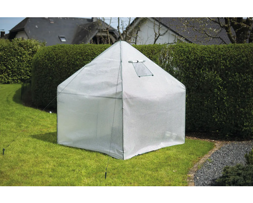 Kleine kas met raam in de tuin.