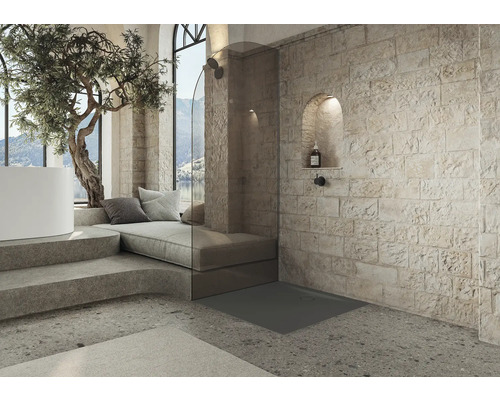 Badkamer met douche, zithoek en stenen muur