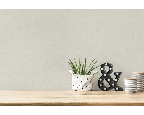 Behang met stoffenlook in kamer met plant en decoratie
