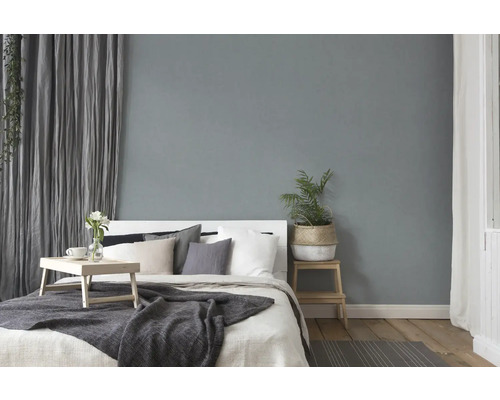 Slaapkamer met bed, beddengoed, kussens, gordijnen en decoratie