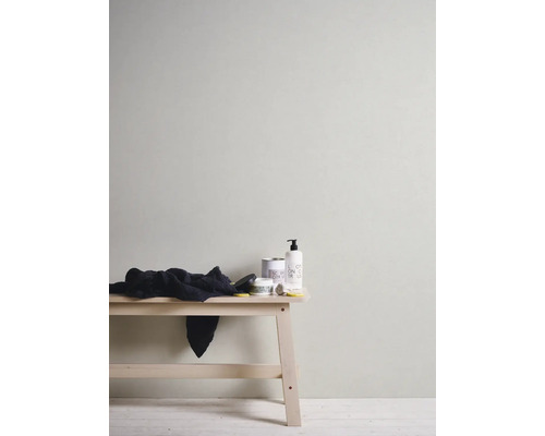 Muur met behang, kruk met handdoek en verzorgingsproducten