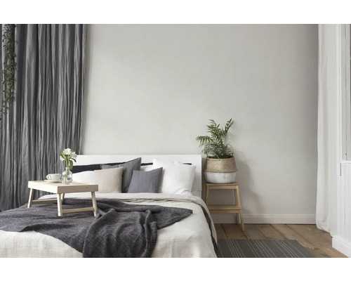 Lichte slaapkamer met bed, nachtkastje, plant en gordijnen