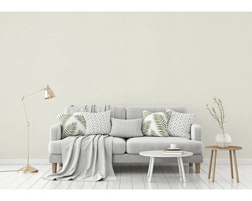 Woonkamer met bank, kussens, deken, tafel en staande lamp