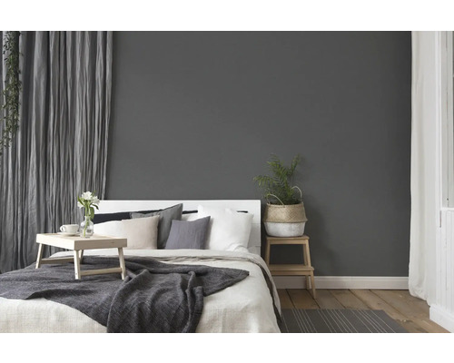 Slaapkamer met bed, nachtkastje en gordijnen voor een gezellige sfeer