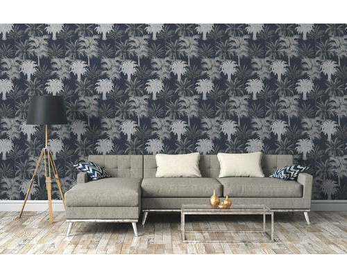 Woonkamer met bank, staande lamp en behang met palmmotief