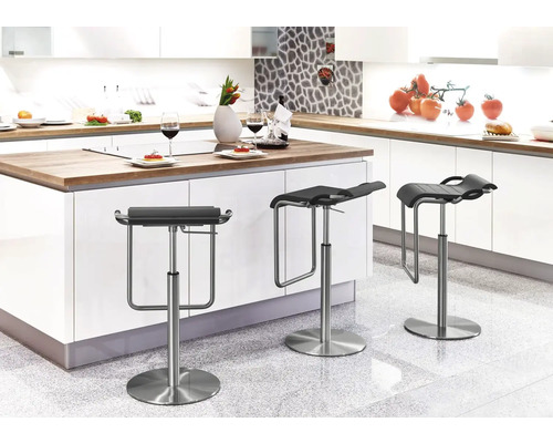 Drie in hoogte verstelbare barkrukken van metaal en kunststof staan in een moderne keuken.