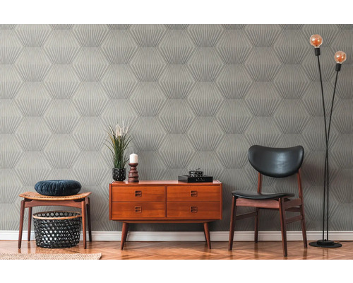 Woonkamer met patroonbehang, commode, stoel en vloerlamp