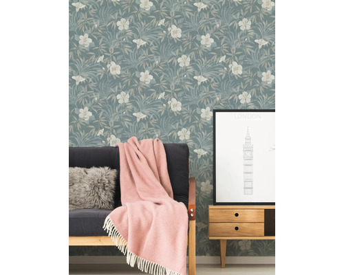 Woonkamer met bloemenbehang, bank, deken en bijzettafel met Londen-motief